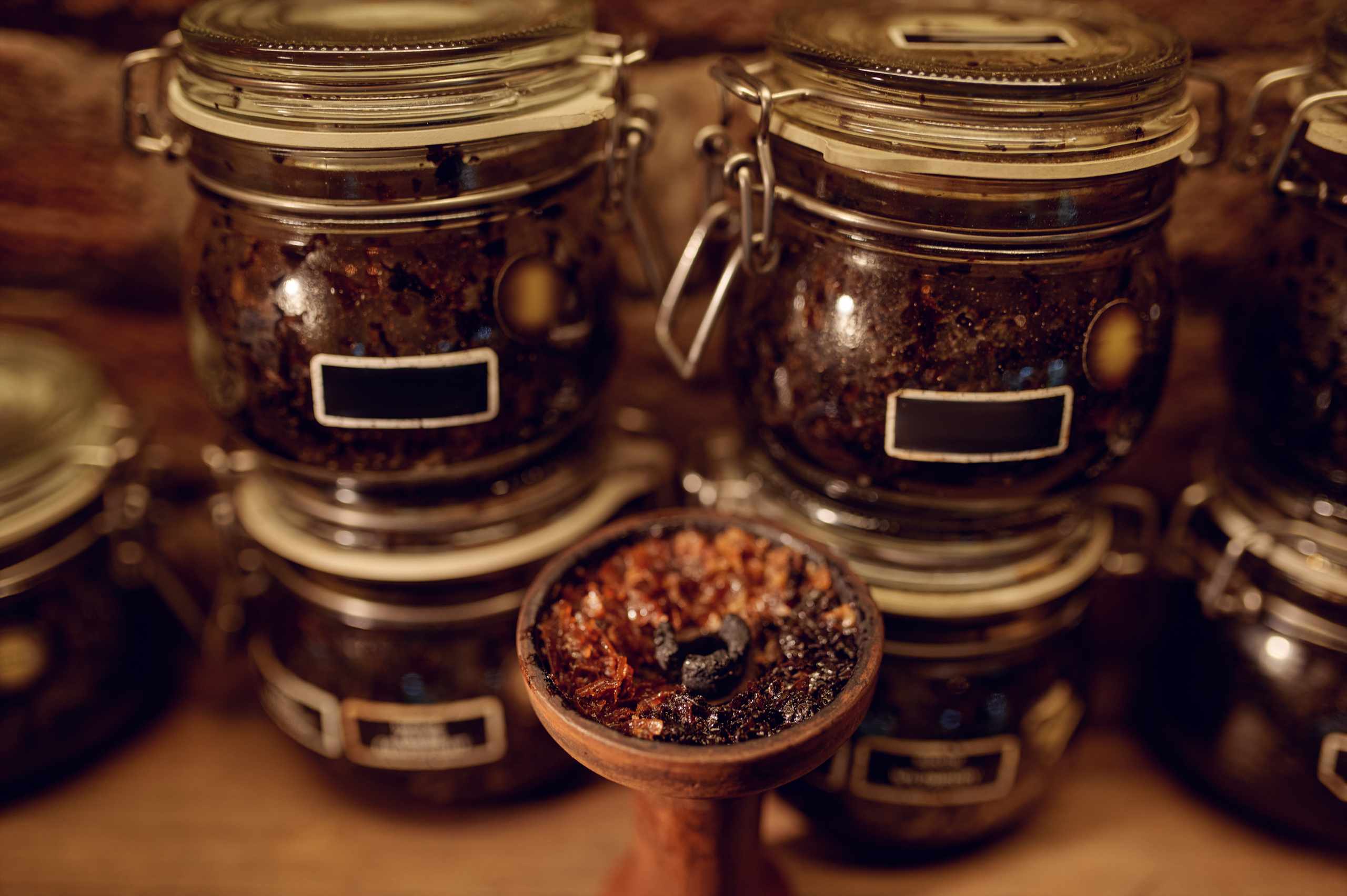Hands preparing ingredients in a glass vessel